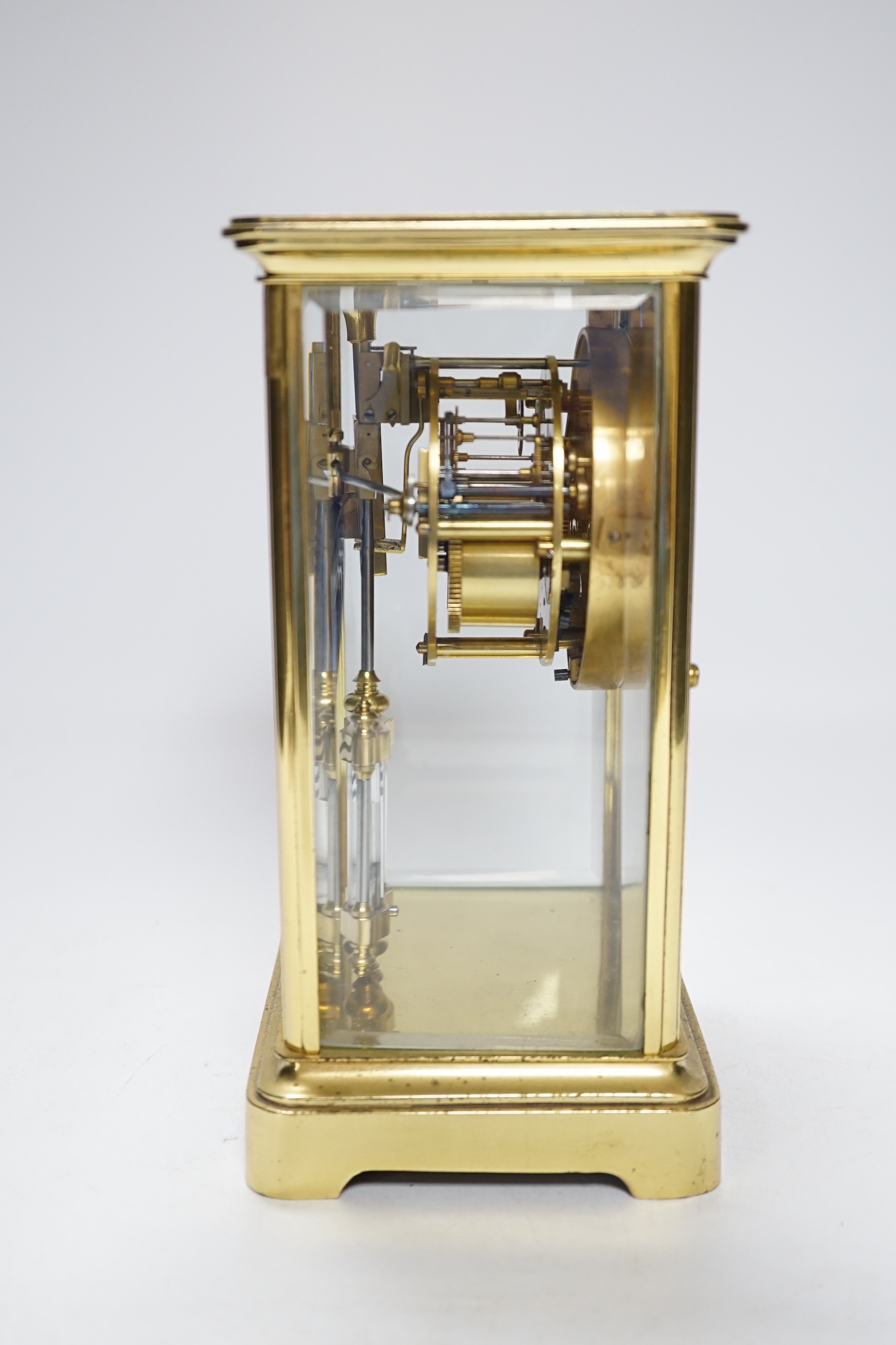 An early 20th century brass four glass clock retailed by Dent, 22cm